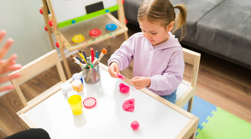 a little girl happily playing a playdough